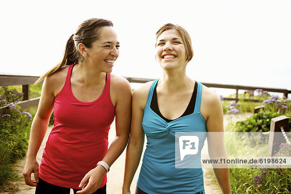 Laughing athletic friends standing together outdoors