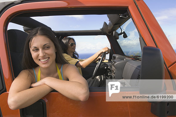 Hispanic woman leaning out window of jeep