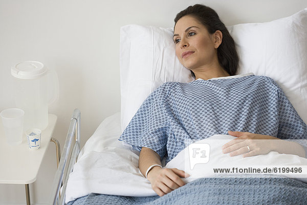Hispanic woman laying in hospital bed