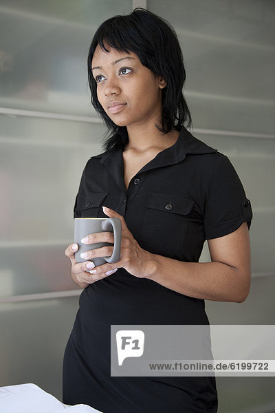 Serious businesswoman holding coffee cup