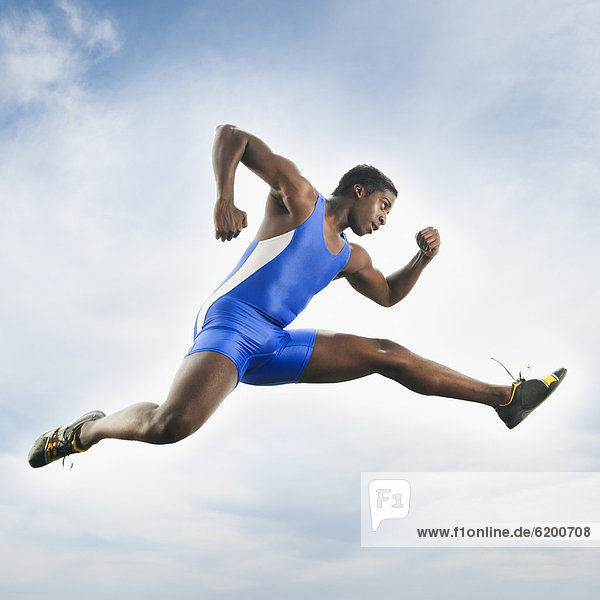 African American athlete jumping in mid-air