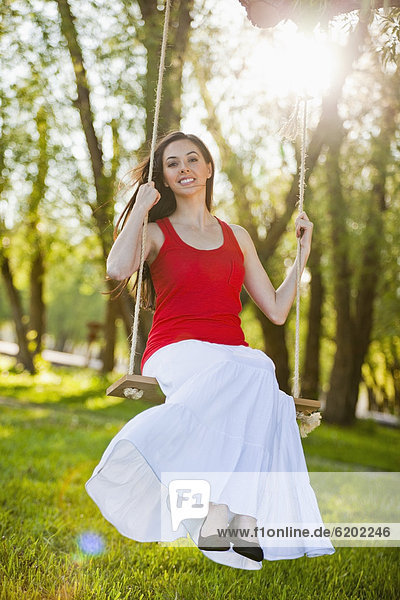 Caucasian woman swinging on swing