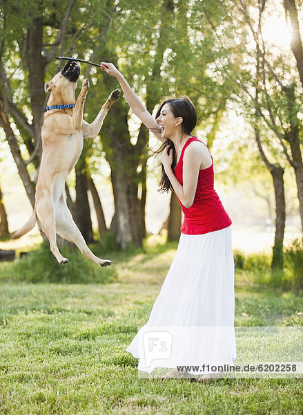 Caucasian woman playing with dog