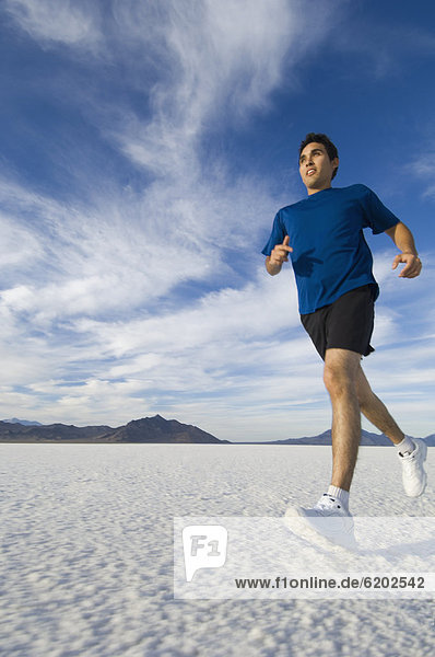 Hispanic man jogging on salt flats