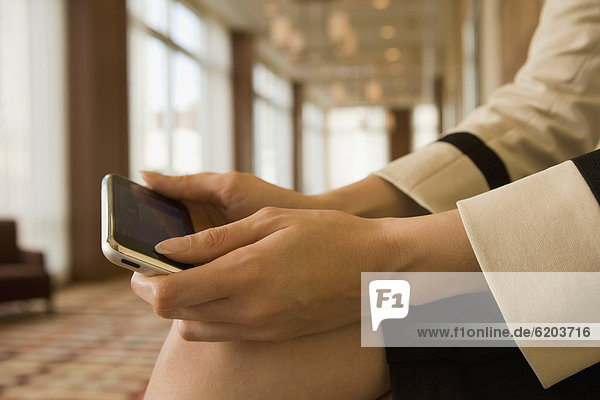 Close up of mixed race businesswoman holding cell phone