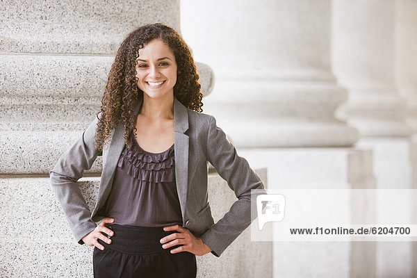 Smiling Caucasian businesswoman standing outdoors