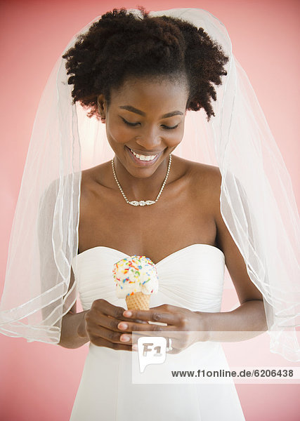 Black bride in wedding dress holding ice cream cone