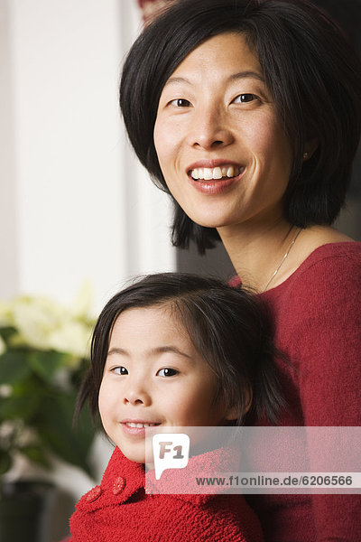 Asian mother with daughter in lap