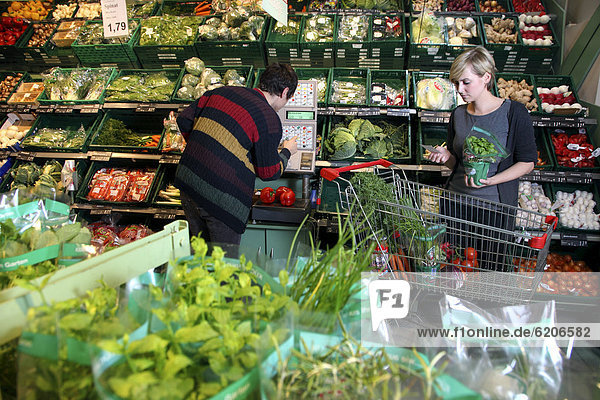 Couple at the supermarket  weighing vegetables with self-service scales  food hall  supermarket  Germany  Europe