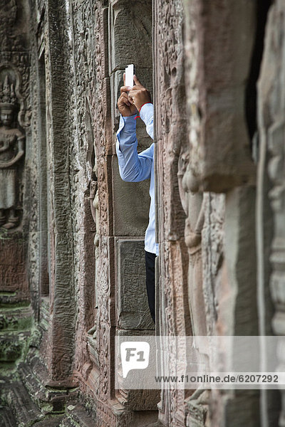 Tourist photographing Ta Prohm temple