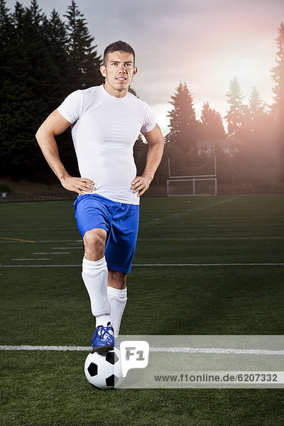 Hispanic athlete standing with soccer ball