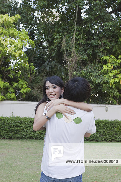 Asian couple hugging outdoors