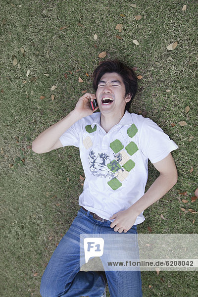 Chinese man laughing and using cell phone