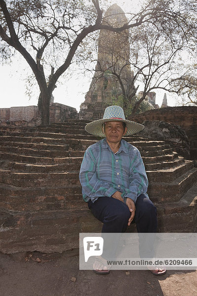 Asian man sitting outside temple