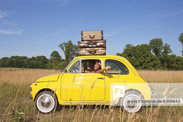 Couple in old-fashioned car on road trip