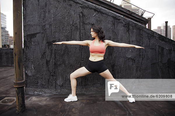Woman practicing yoga on rooftop