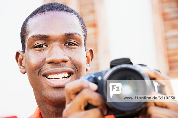 African man holding digital camera