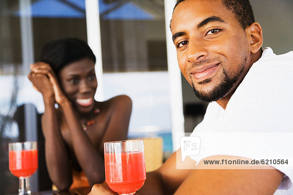 African couple drinking cocktails on patio