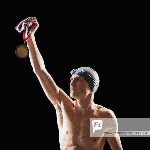 Jugendlicher  Europäer  Junge - Person  Schutzbrille  Mütze  halten  schwimmen  Medaille Schwimmkappe und Schwimmbrille