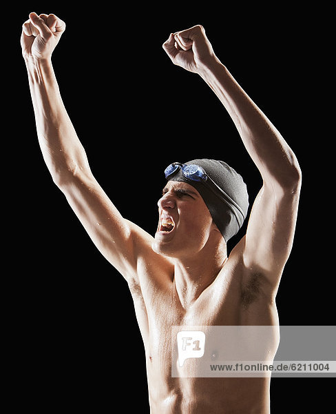Caucasian teenage boy in swim cap and goggles cheering