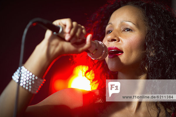 Hispanic woman singing in nightclub