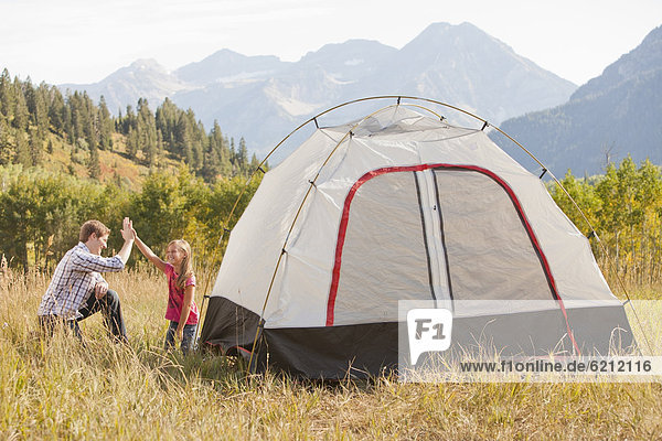 Caucasian father and daughter setting up tent