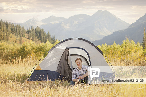 Caucasian man sitting in tent
