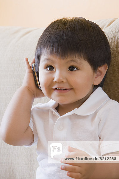 Hispanic baby boy using cell phone