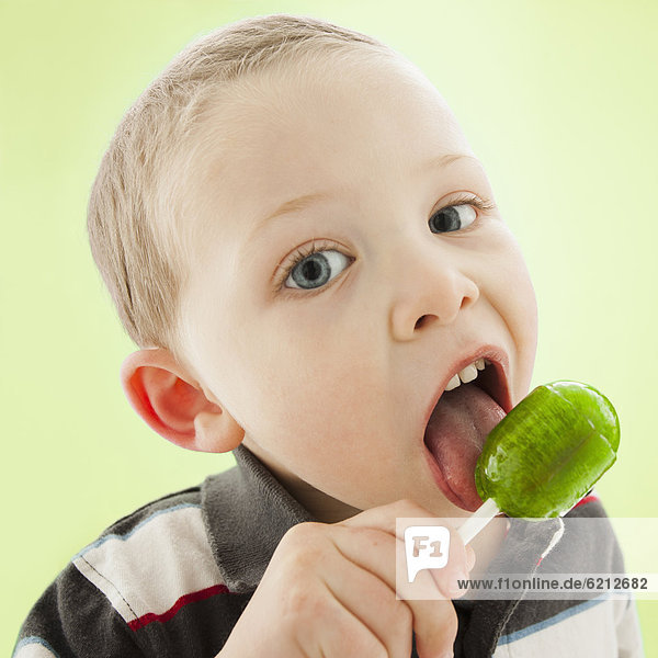 Caucasian boy licking lollipop