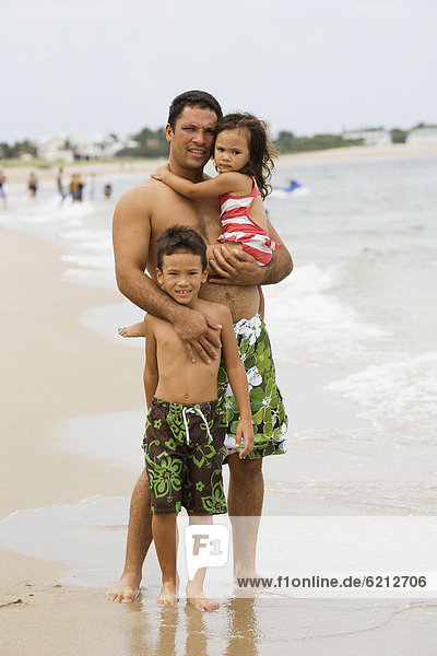 Father with daughter and son on beach