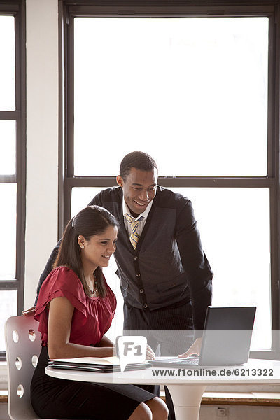 Geschäftsmann und Geschäftsfrau arbeiten mit Laptop