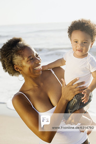 African mother holding son on beach