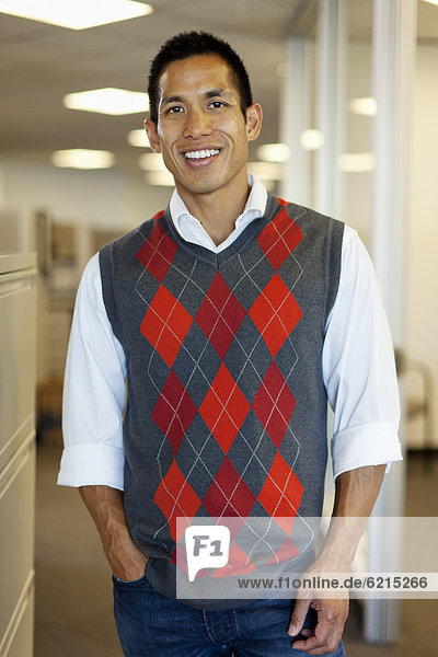 Smiling mixed race businessman standing in office