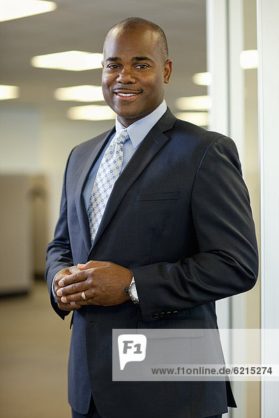 Smiling African American businessman standing in office