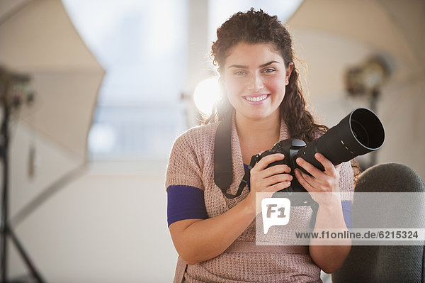 Mixed race woman holding camera
