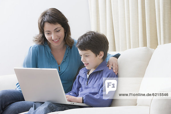 Hispanic mother and son using laptop