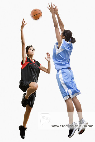 Mixed race women playing basketball