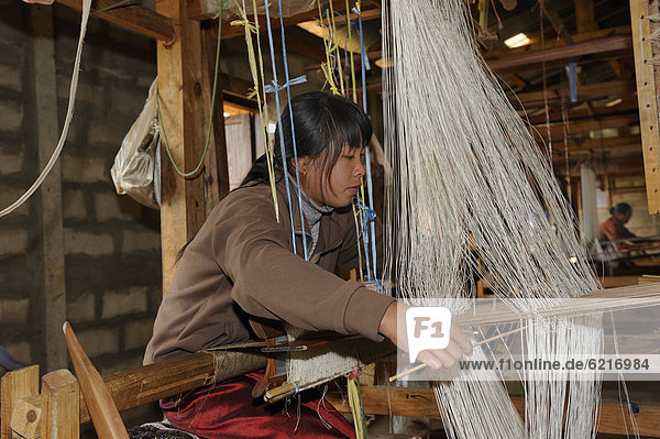 Weberin arbeitet an einem Handwebstuhl in einer Seidenmanufaktur bei der Stadt Phansavan  Laos  Südostasien  Asien