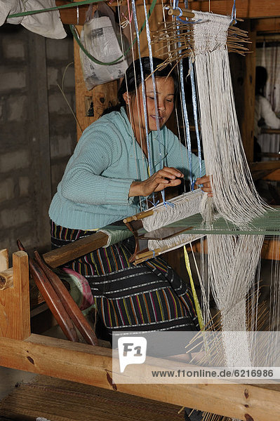 Weaver working on a hand loom in a silk factory near the town of Phansavan  Laos  Southeast Asia  Asia