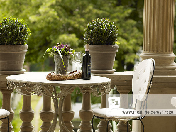 Bistro table with bread and wine on the balcony of a classical building