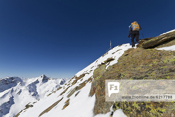 Mountaineer at the summit ridge of Mt Kraspesspitze  Kuehtai region  Sellrainer Mountains  Tyrol  Austria  Europe