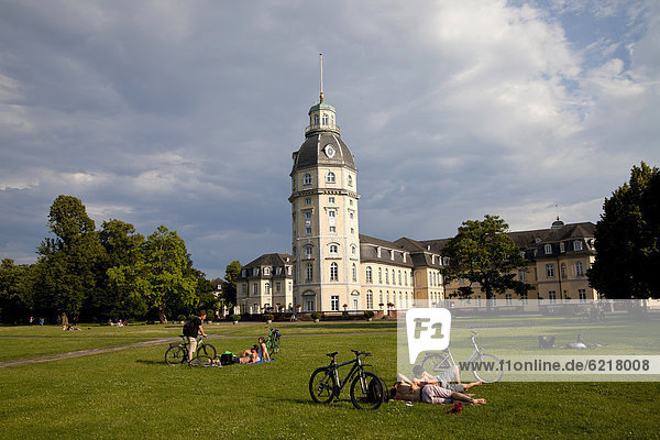 People sunbathing on the lawn in the park in front of Karlsruhe Palace  Karlsruhe  Baden-Wuerttemberg  Germany  Europe