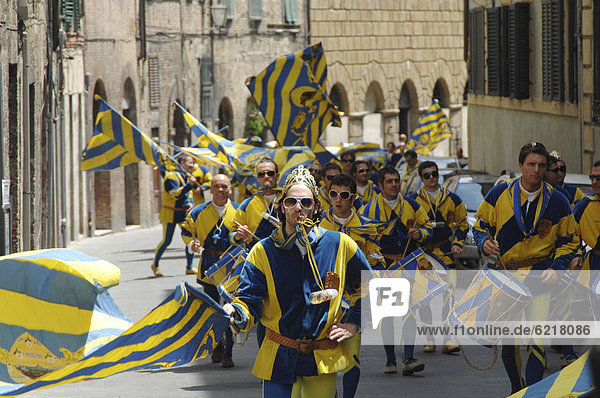 In mittelalterliche Gewänder gekleidete Menschen ziehen nach dem Sieg ihres Stadtteiles durch alle Stadtteile beim Palio  Siena  Toskana  Italien  Europa