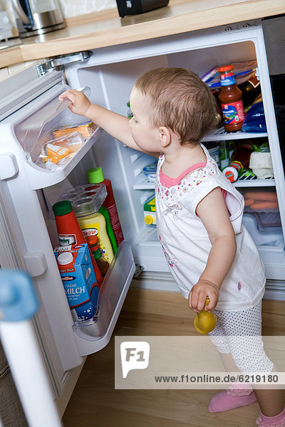 Kleines Mädchen am Kühlschrank