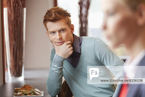 Man in a restaurant looking at a businesswoman