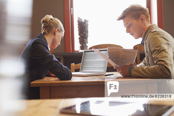 Business couple sitting in a restaurant and working