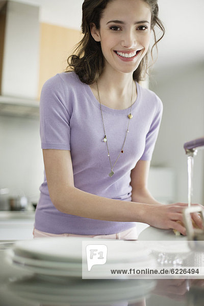 Frau beim Geschirrspülen in der Küche