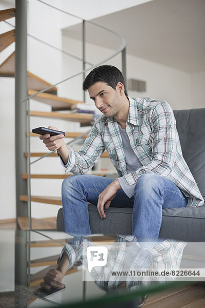 Man changing channels with a remote control