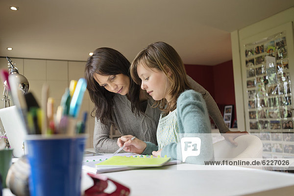 Girl studying with her mother at home