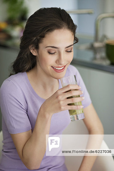 Woman holding a glass of cold soup and smiling